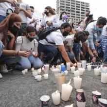 Estudiantes colocando veladoras en la glorieta para recordar a las víctimas