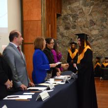 Egresada recibiendo su reconocimiento de manos de la rectora del Sistema de Universidad Virtual